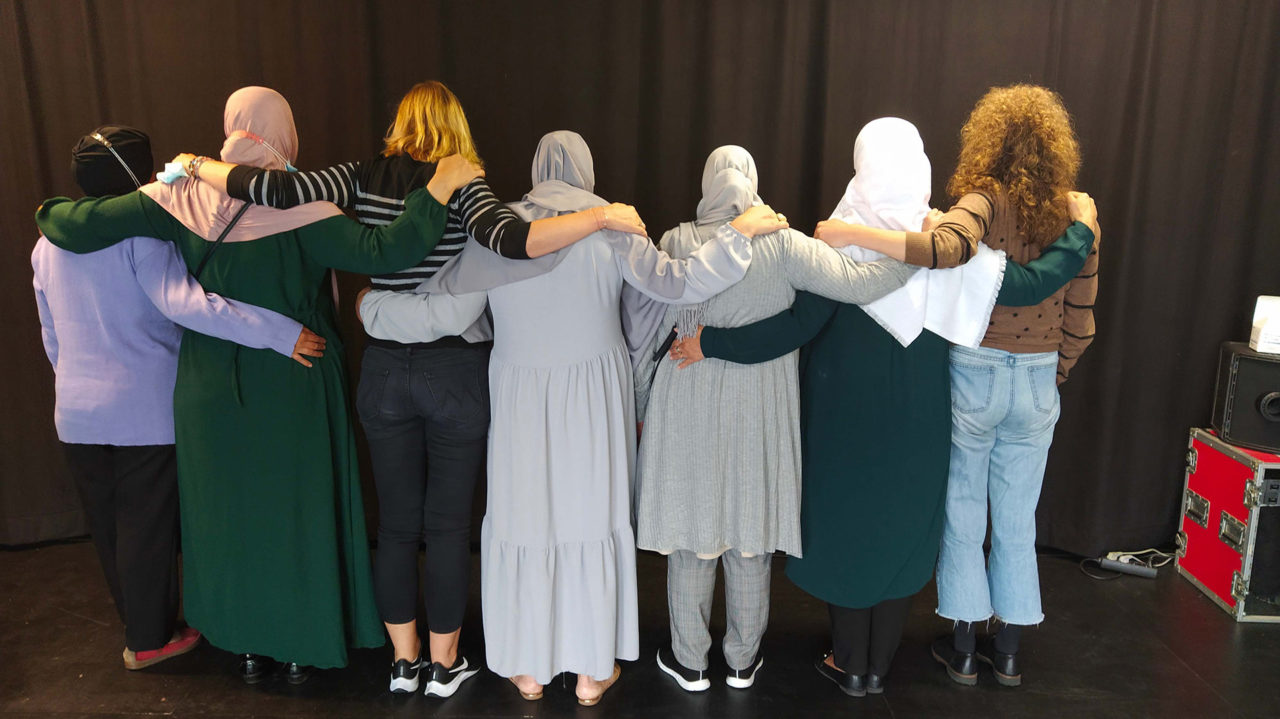 Atelier avec des femmes du quartier, organisé par le PCS Querelle. Femmes de dos qui se tiennent par les épaules.