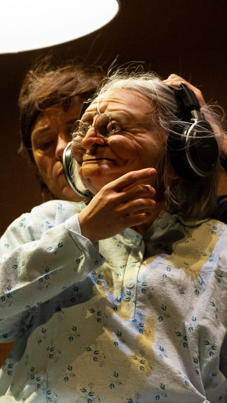 Marionnette de vieille femme portant un casque audio