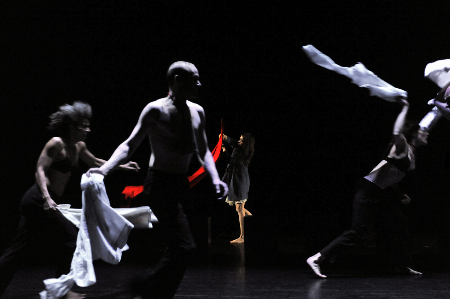 Danseurs courant sur scène avec des tissus