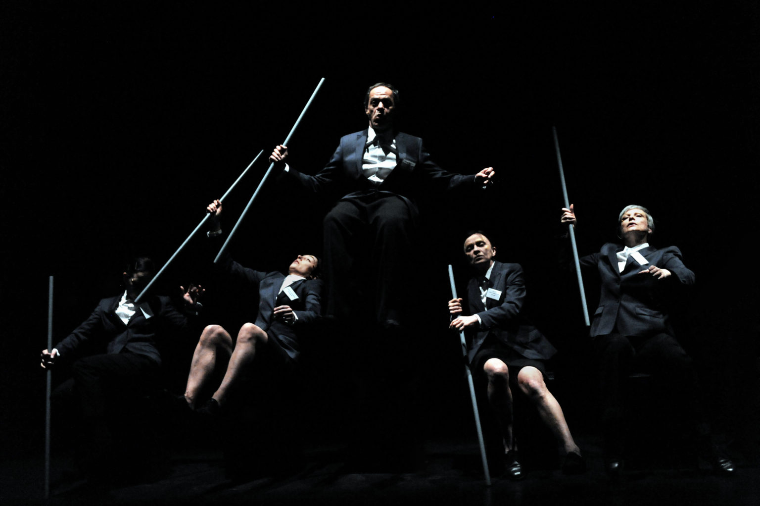 Danseurs sur scène avec des perches