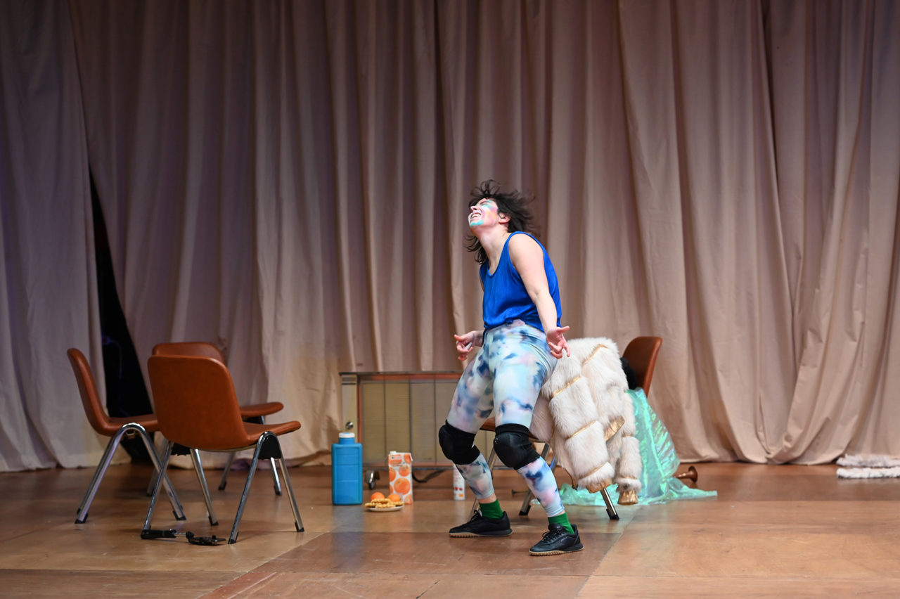La comédienne Chloé Larrère danse. Elle porte un legging de couleur et un haut bleu.