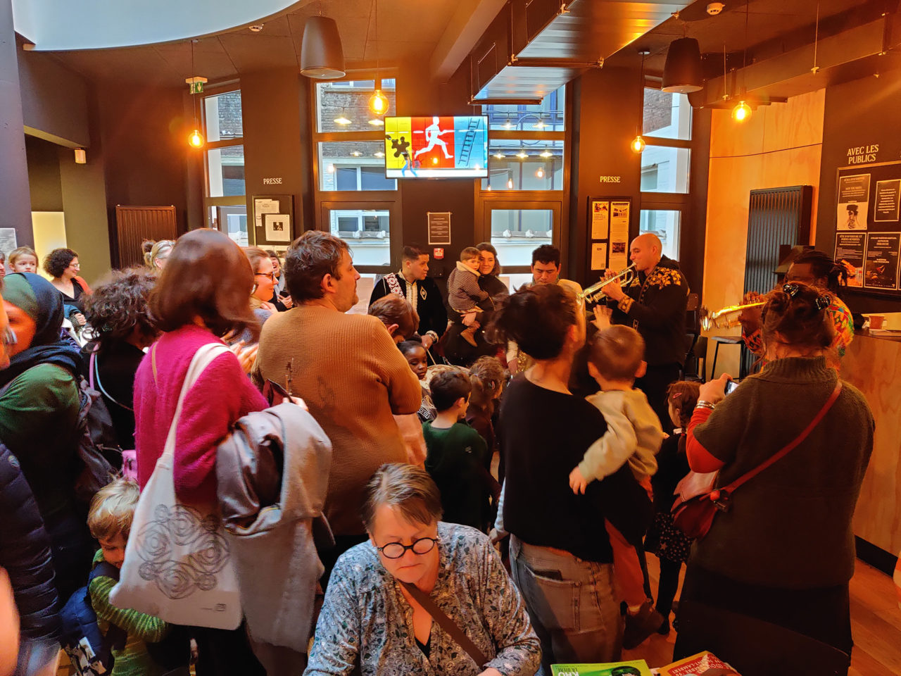 Photo prise lors de la fête d'ouverture du nouveau foyer, en février 2024. Il y a un concert/fanfare de MetX et plein de gens de tous les âges.