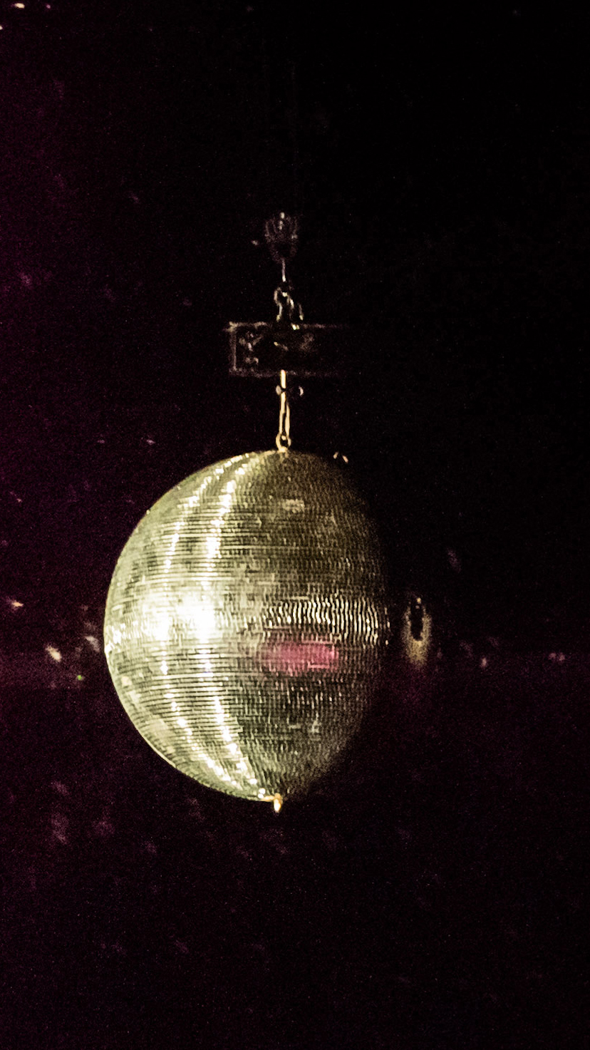 Boule disco scintillante avec des lumières mauve sur une scène