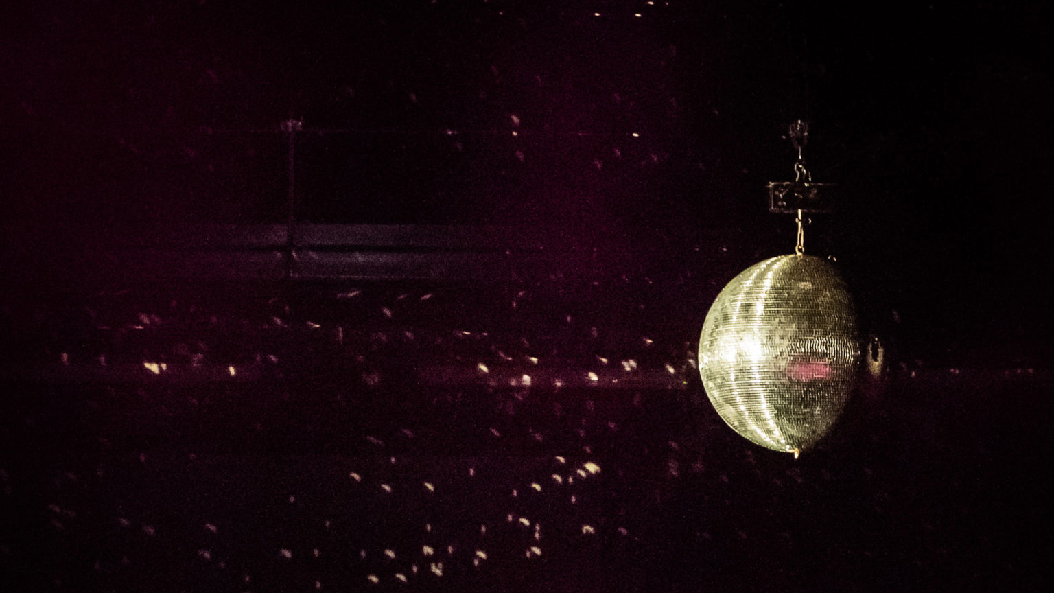 Boule disco scintillante avec des lumières mauve sur une scène