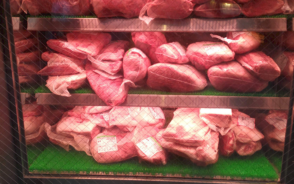 des morceaux de viandes emballés dans un frigo.
