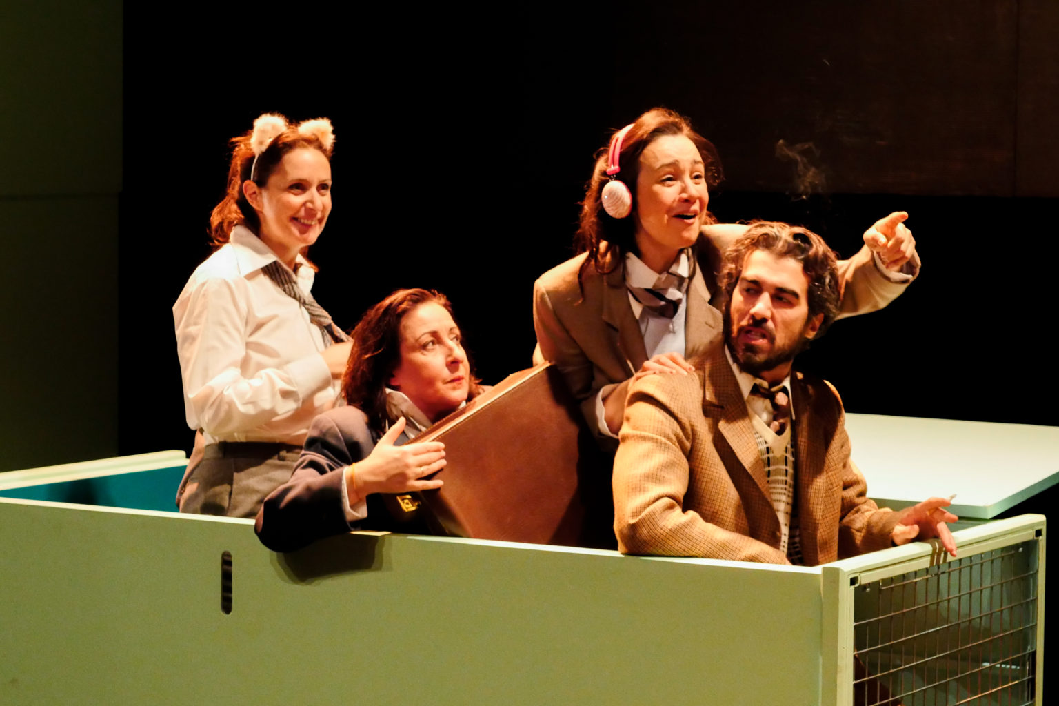 Myriem Akheddiou, Jasmina Douieb, Monia Douieb et Othmane Moumen sont dans une boite sur scène. Deux actrices portent un serre-tête et une tient une valise dans ses mains. Othmane Moumen vers l'avant parle en se retournant de façon contrariée.